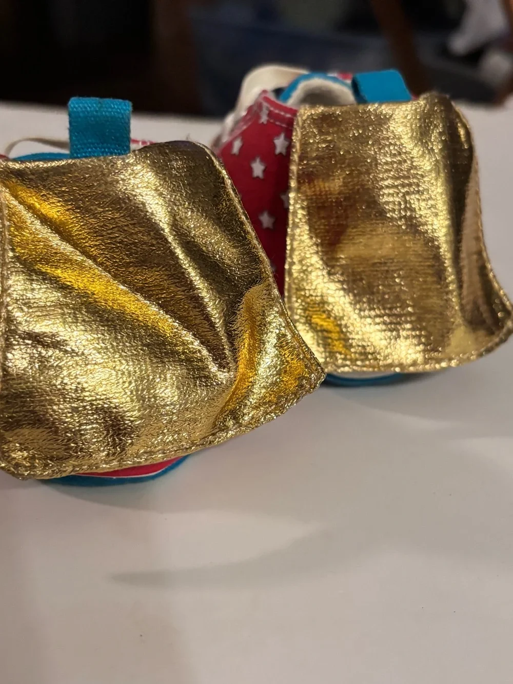 DC Comics baby sneaker with Wonder Woman logo. Red canvas with Gold Capes.